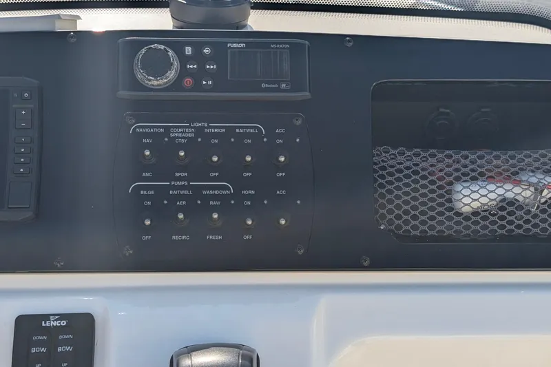 Slide: The Image of Control panel of 2019 Scout 215 XSF boat with various switches and a Fusion audio system. - 21