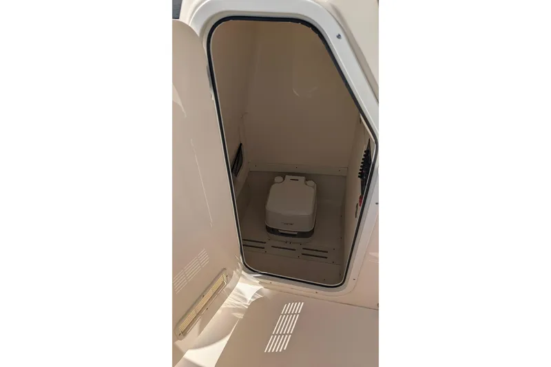 Slide: The Image of 2019 Scout 215 XSF boat storage compartment with portable toilet. - 27