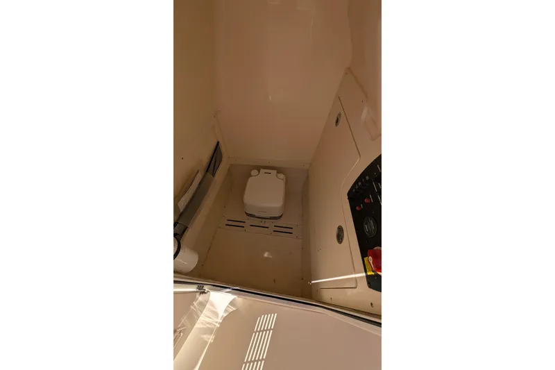 Slide: The Image of 2019 Scout 215 XSF boat interior with compact toilet and control panel. - 28