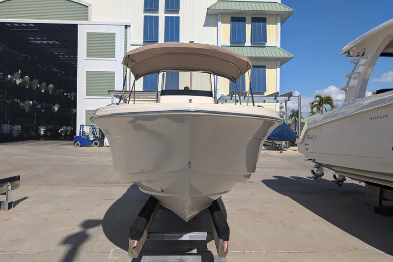 Slide: The Image of 2019 Scout 215 XSF boat on display at a marina under clear blue skies. - 3