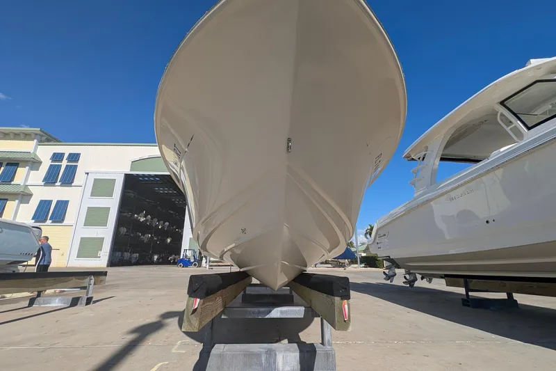 Slide: The Image of 2019 Scout 215 XSF boat on display at a marina under clear blue skies. - 45