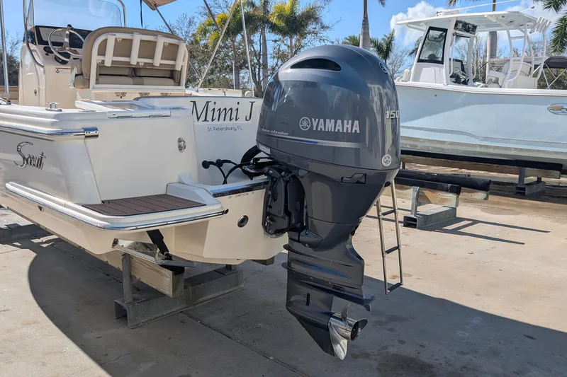 Slide: The Image of 2019 Scout 215 XSF boat with Yamaha 150 outboard motor, docked outdoors. - 8