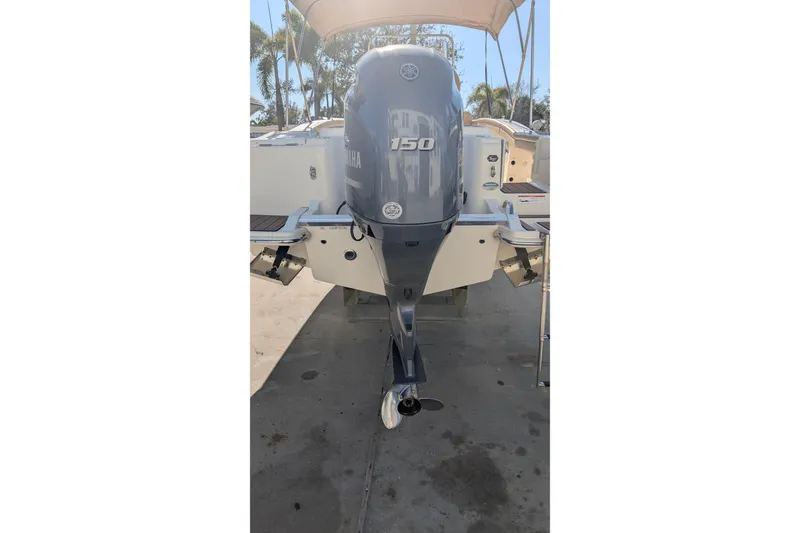 Slide: The Image of 2019 Scout 215 XSF boat with Yamaha 150 outboard motor, docked outdoors. - 9