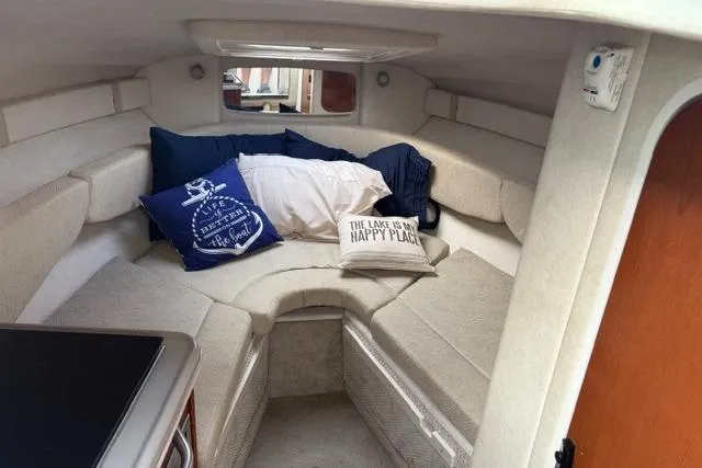 Slide: The Image of 2008 Sea Ray 240 Sundancer cabin interior with cozy seating and decorative pillows. - 10