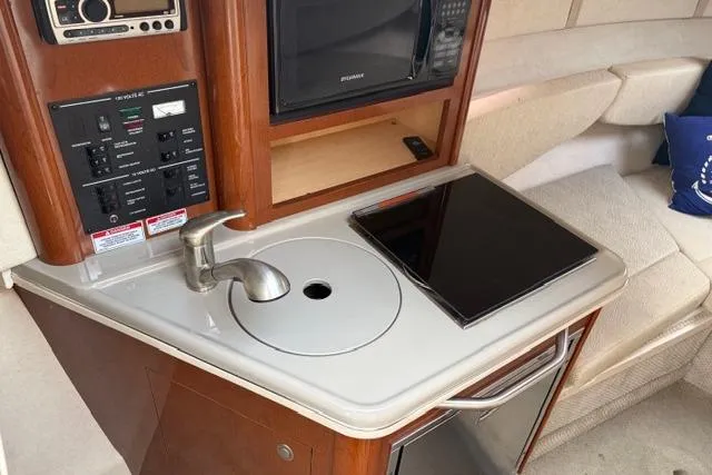 Slide: The Image of 2008 Sea Ray 240 Sundancer cabin with kitchenette, sink, and microwave. - 11