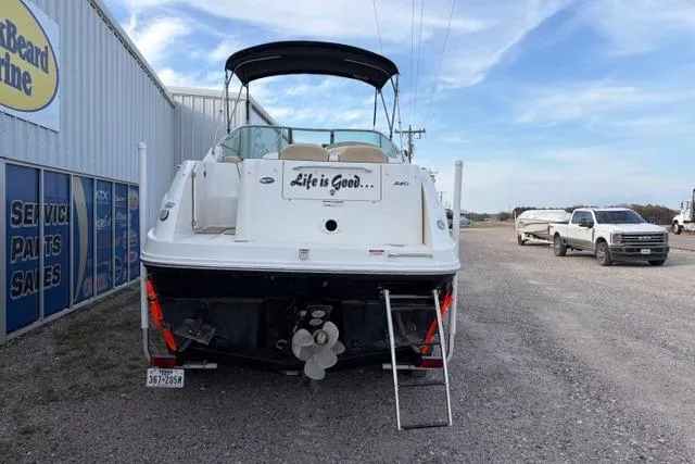 Slide: The Image of 2008 Sea Ray 240 Sundancer boat with "Life is Good" text, parked near dealership. - 5