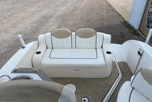 Slide: The Image of 2008 Sea Ray 240 Sundancer boat interior with white seating and beige accents. - 9