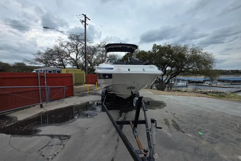 Slide: The Image of 2022 Crownline Eclipse E255 boat on trailer, parked outdoors near marina. - 62