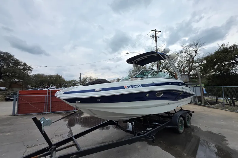 Slide: The Image of 2022 Crownline Eclipse E255 boat on trailer, parked outdoors under cloudy sky. - 69