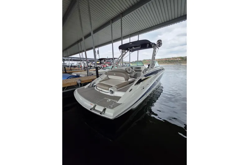 Slide: The Image of 2022 Crownline Eclipse E255 boat docked under a covered marina. - 80