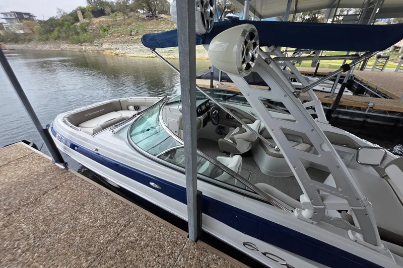 Slide: The Image of 2022 Crownline Eclipse E255 boat docked, featuring sleek design and spacious seating. - 81