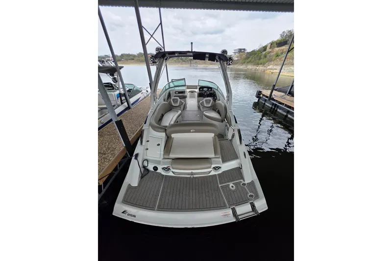 Slide: The Image of 2022 Crownline Eclipse E255 boat docked, showcasing spacious seating and sleek design. - 82