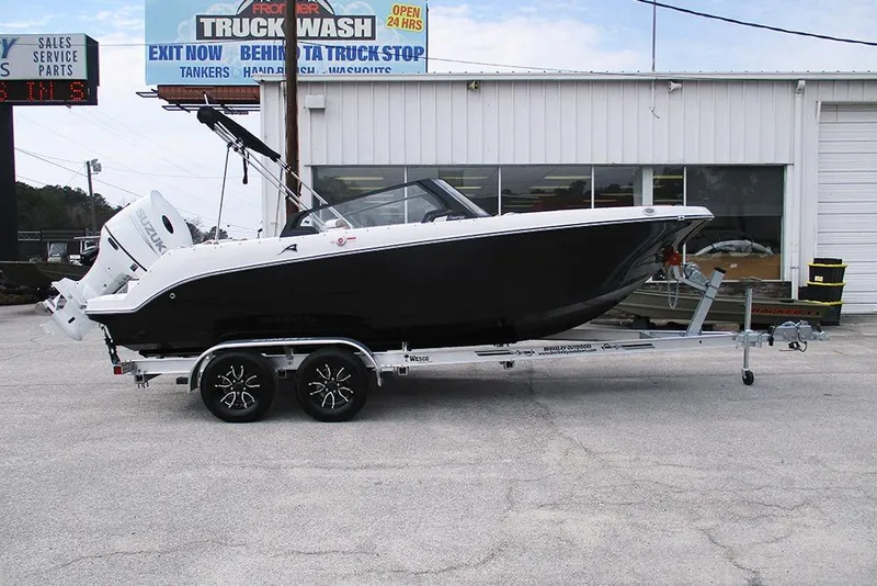 The Image of 2026 Stingray 20 SBX boat on trailer, parked outside a service center. - 1