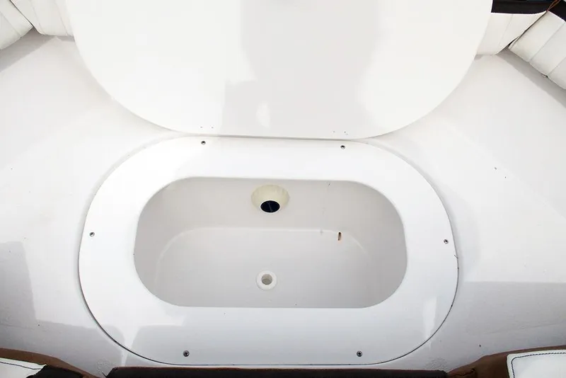 Slide: The Image of Open storage compartment on 2026 Stingray 20 SBX boat, featuring a white interior. - 11