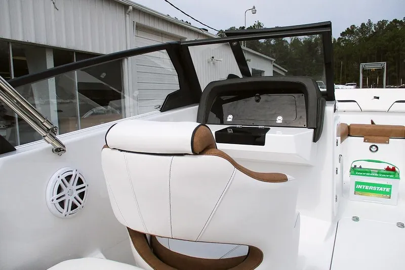 Slide: The Image of 2026 Stingray 20 SBX boat interior with white seating and dashboard, parked near a building. - 29