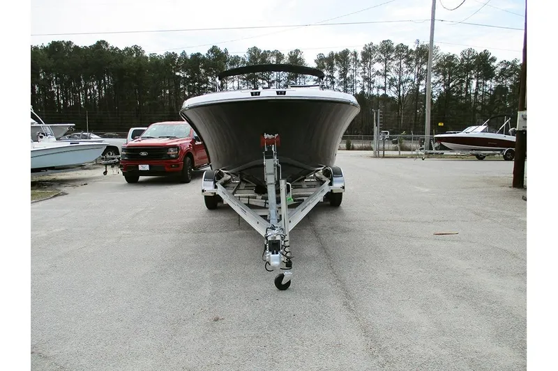 Slide: The Image of 2026 Stingray 20 SBX boat on trailer, parked near red truck, outdoor setting. - 3