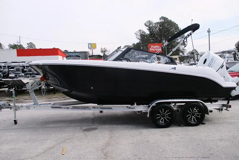 Slide: The Image of 2026 Stingray 20 SBX boat on trailer, black hull, outdoor storage background. - 5