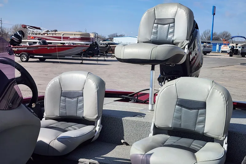 Slide: The Image of 2018 Tracker Pro 170 boat interior with gray seats in a marina setting. - 6