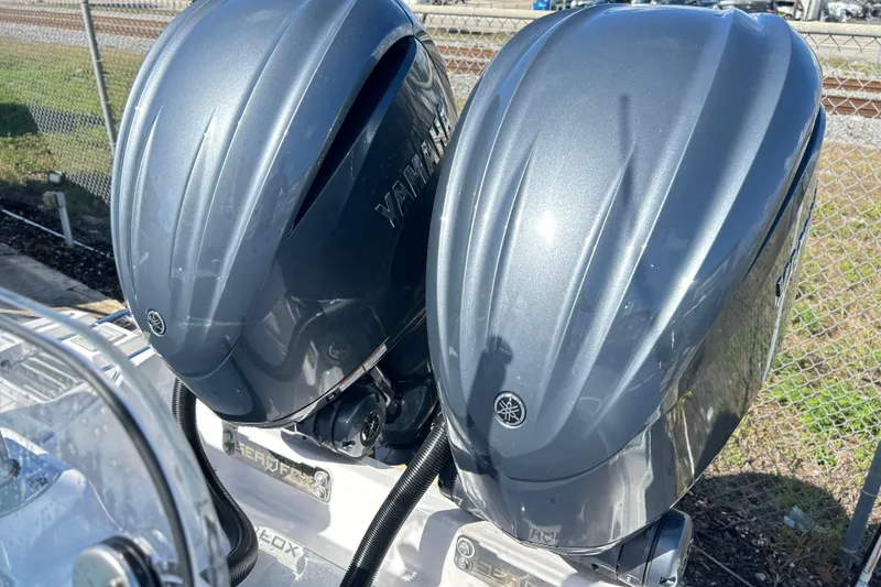 Slide: The Image of 2026 Sea Fox 288 Commander with dual Yamaha outboard engines, parked near a fence. - 26