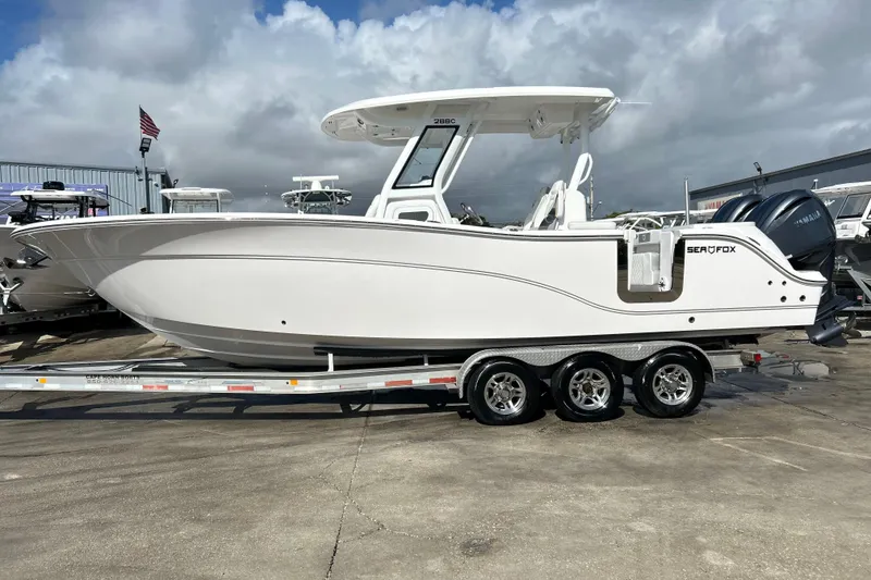 Slide: The Image of 2026 Sea Fox 288 Commander boat on trailer, displayed outdoors under cloudy sky. - 7