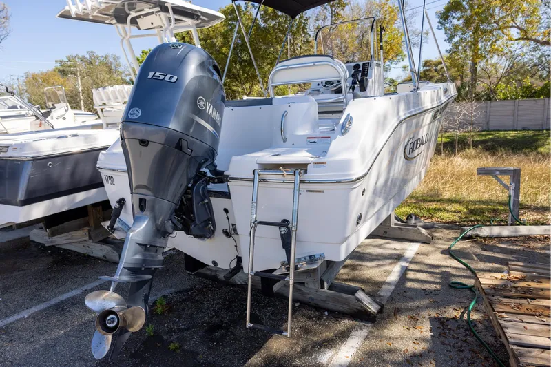 Slide: The Image of 2020 Robalo R202 Explorer boat with Yamaha 150 outboard engine, parked outdoors. - 2