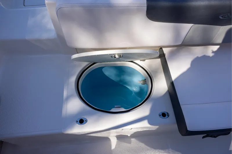 Slide: The Image of 2020 Robalo R202 Explorer boat with open storage compartment, white seating, and blue interior. - 9