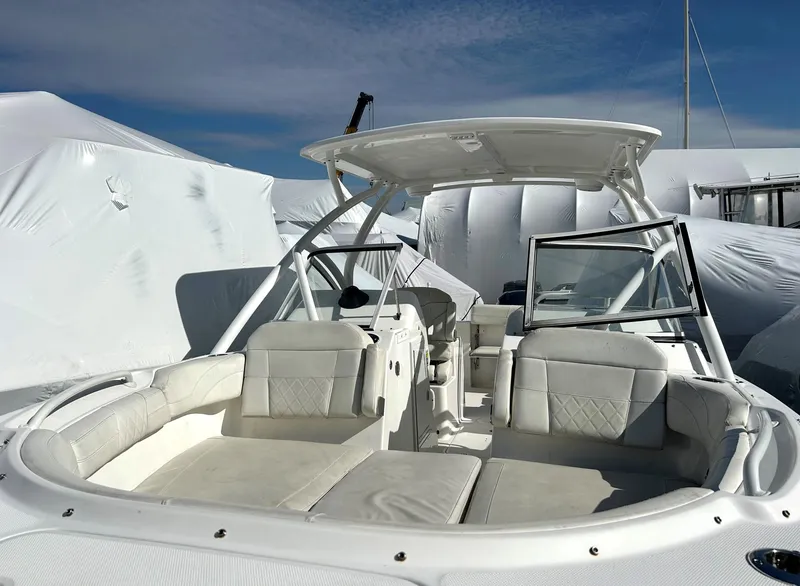 Slide: The Image of 2020 Edgewater 348 CX boat with white seating and canopy under clear blue sky. - 10