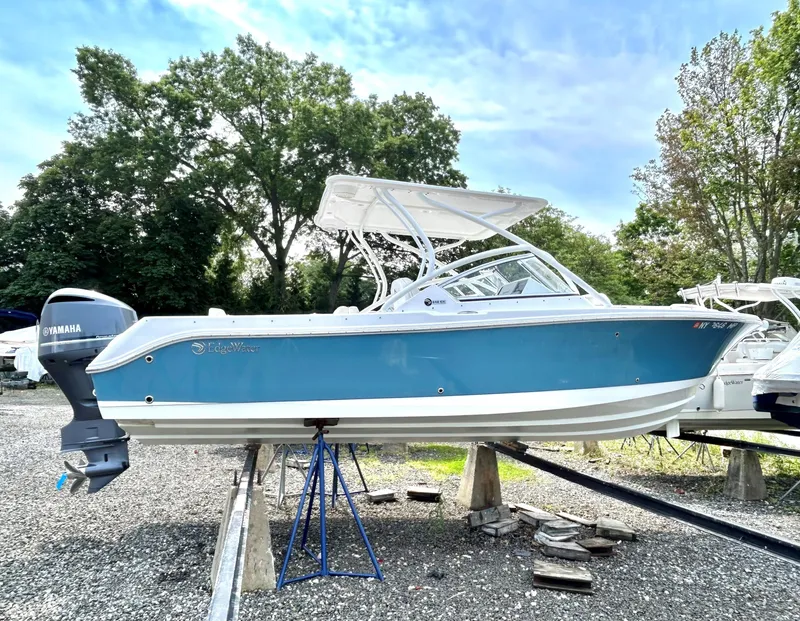 Slide: The Image of 2020 Edgewater 248 CX boat with blue hull on display outdoors. - 23