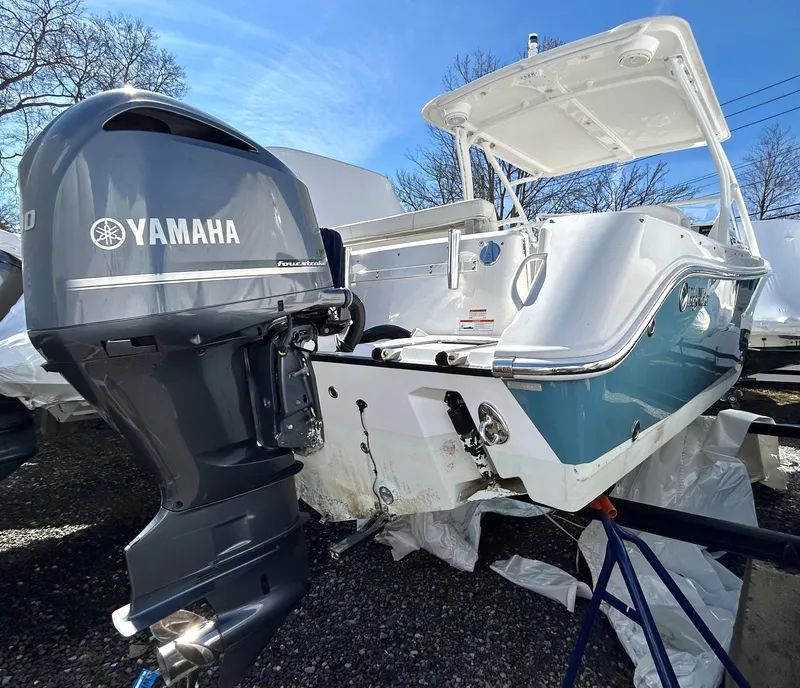 Slide: The Image of 2020 Edgewater 348 CX boat with Yamaha outboard motor, parked outdoors. - 6
