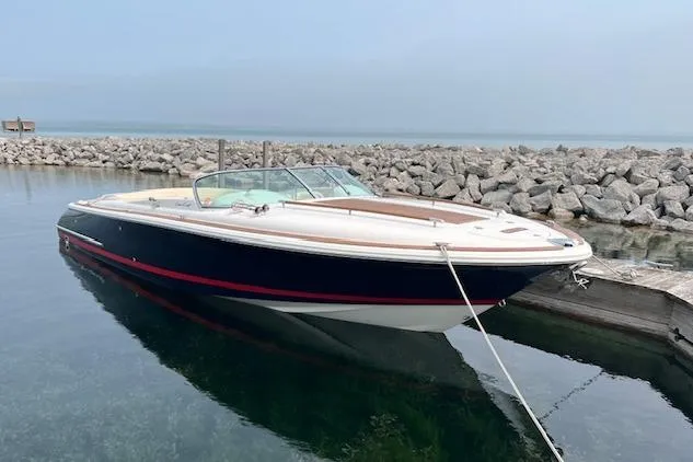 The Image of 2006 Chris-Craft Corsair 28 boat docked by rocky shoreline. - 0