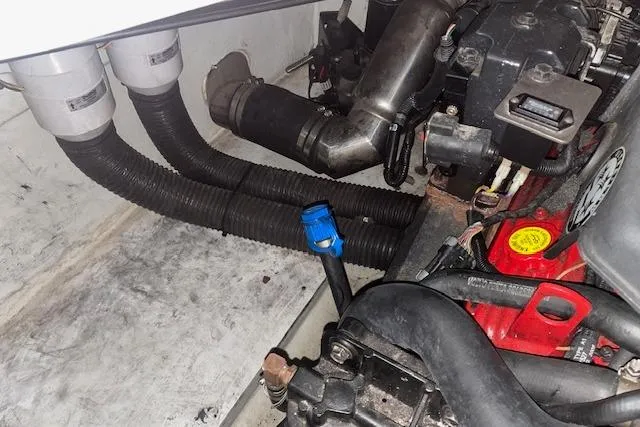 Slide: The Image of Engine compartment of a 2006 Chris-Craft Corsair 28 boat, showing hoses and components. - 12