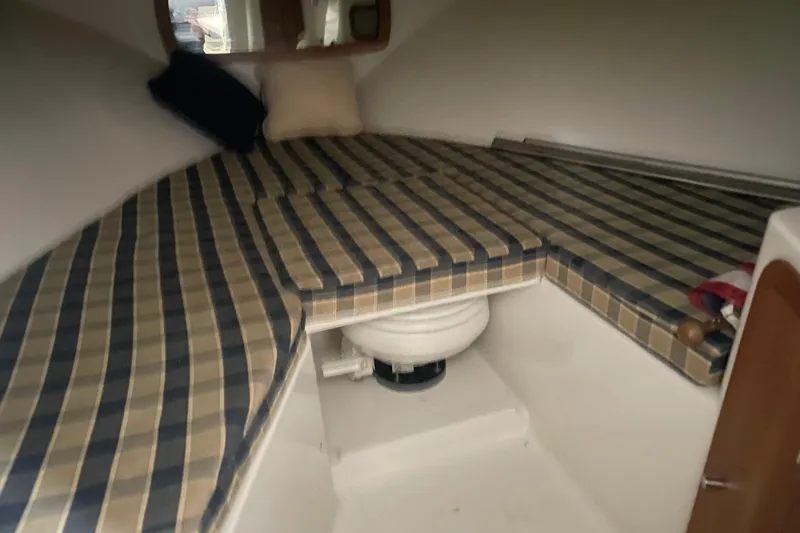 Slide: The Image of 2006 Chris-Craft Corsair 28 cabin interior with striped cushions and compact toilet. - 15