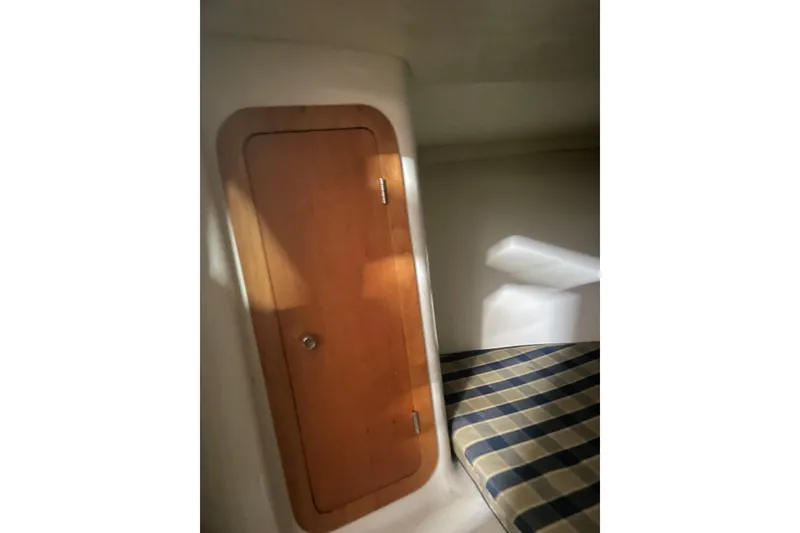 Slide: The Image of Interior cabin of 2006 Chris-Craft Corsair 28 with wooden door and plaid cushion. - 16