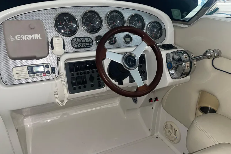 Slide: The Image of 2006 Chris-Craft Corsair 28 boat dashboard with Garmin navigation and classic steering wheel. - 3