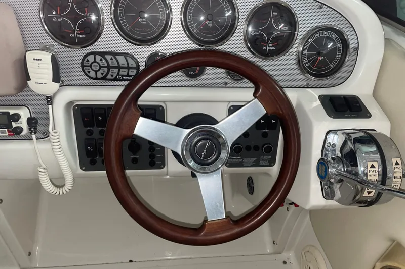 Slide: The Image of 2006 Chris-Craft Corsair 28 dashboard with wooden steering wheel and control panel. - 9