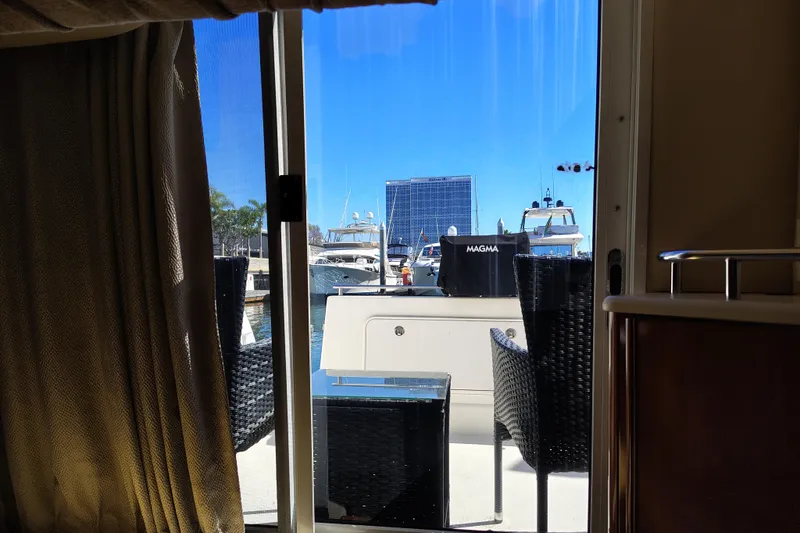 Slide: The Image of 2006 Meridian 459 Motoryacht interior view with marina backdrop and outdoor seating. - 13