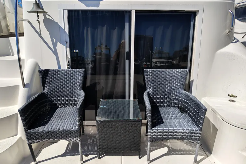 Slide: The Image of Outdoor seating on 2006 Meridian 459 Motoryacht, featuring two wicker chairs and a table. - 20