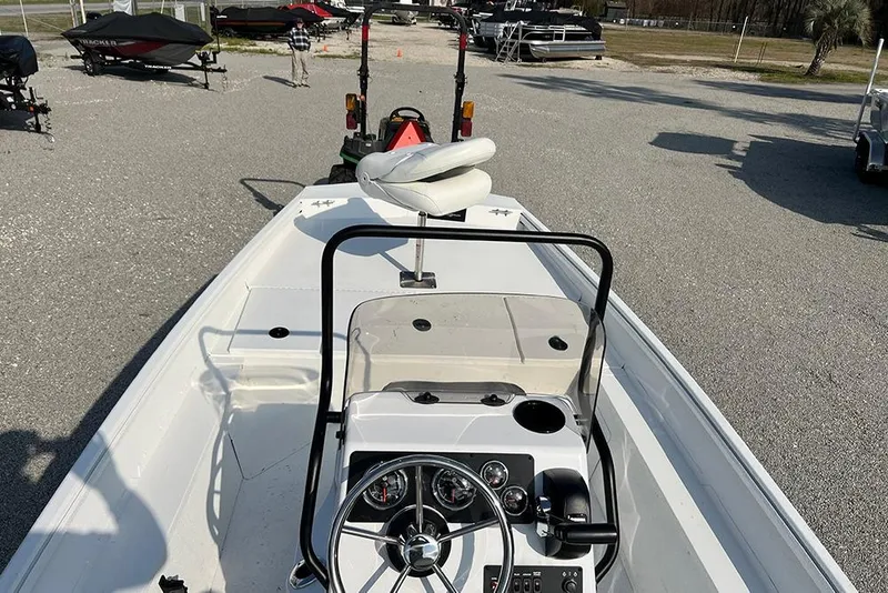 Slide: The Image of 2026 G3 Bay 17 boat interior with steering console and seating, parked outdoors. - 4