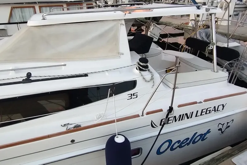 Slide: The Image of 2013 Gemini Legacy 35 catamaran named "Ocelot" docked at a marina. - 2