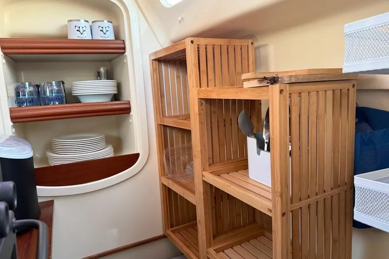 Slide: The Image of Cozy kitchen area in 2013 Gemini Legacy 35 sailboat with wooden shelves and dishware. - 26