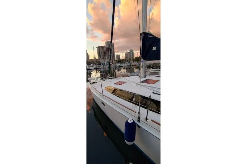 Slide: The Image of Sailboat Gemini Legacy 35, 2013 model, docked at marina during sunset with city skyline. - 3