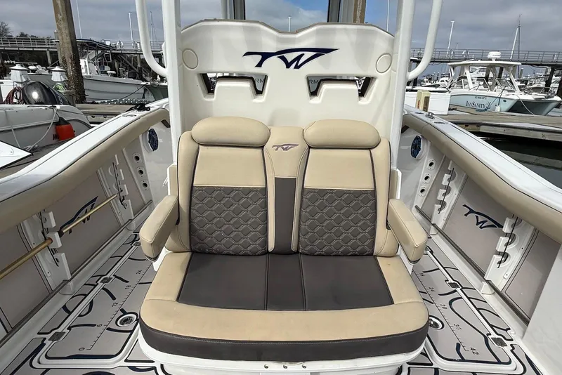 Slide: The Image of 2022 Tidewater 292 CC Adventure boat interior with cushioned seating and elegant design. - 10
