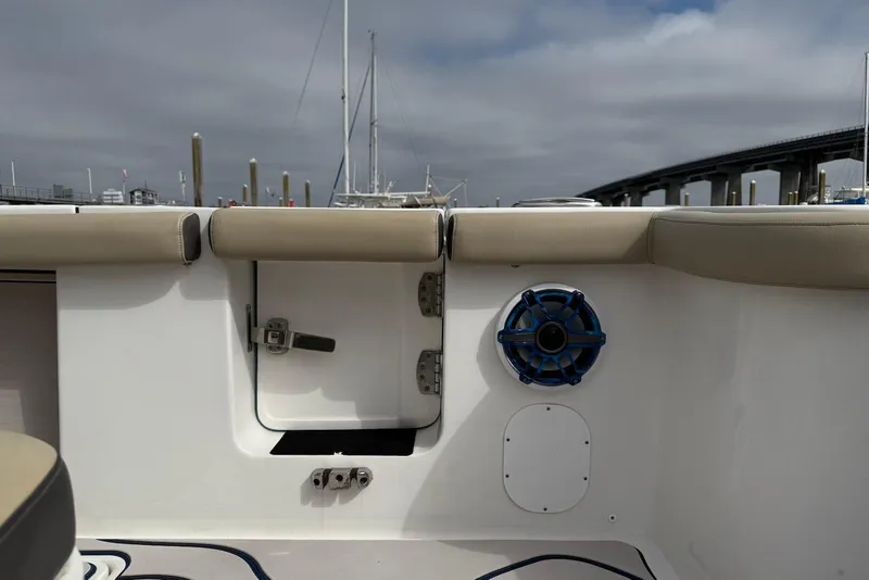 Slide: The Image of 2022 Tidewater 292 CC Adventure boat interior with speaker and cushioned seating. - 11