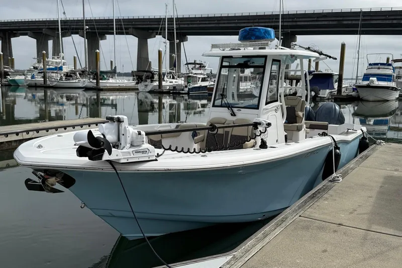Slide: The Image of 2022 Tidewater 292 CC Adventure boat docked at marina with bridge in background. - 3