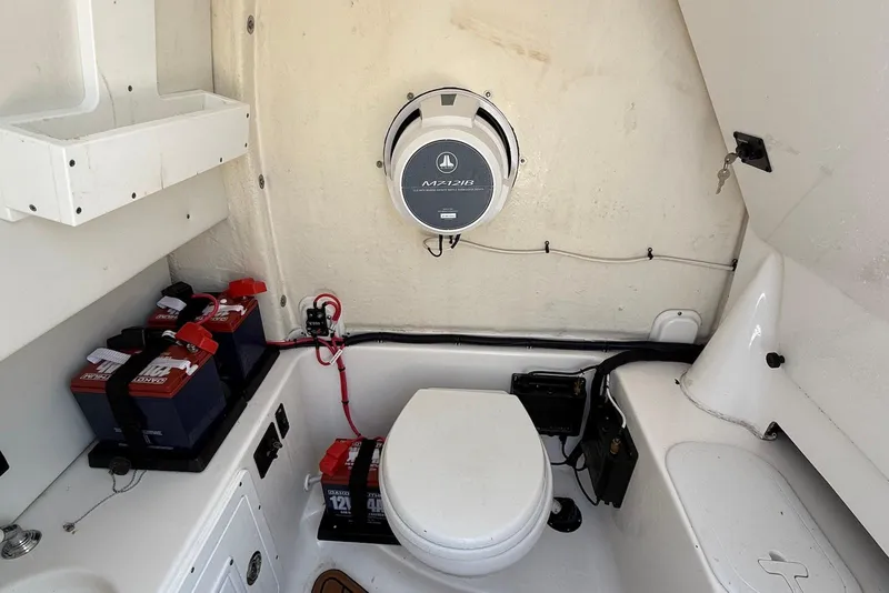 Slide: The Image of 2022 Tidewater 292 CC Adventure boat interior with batteries and toilet. - 31