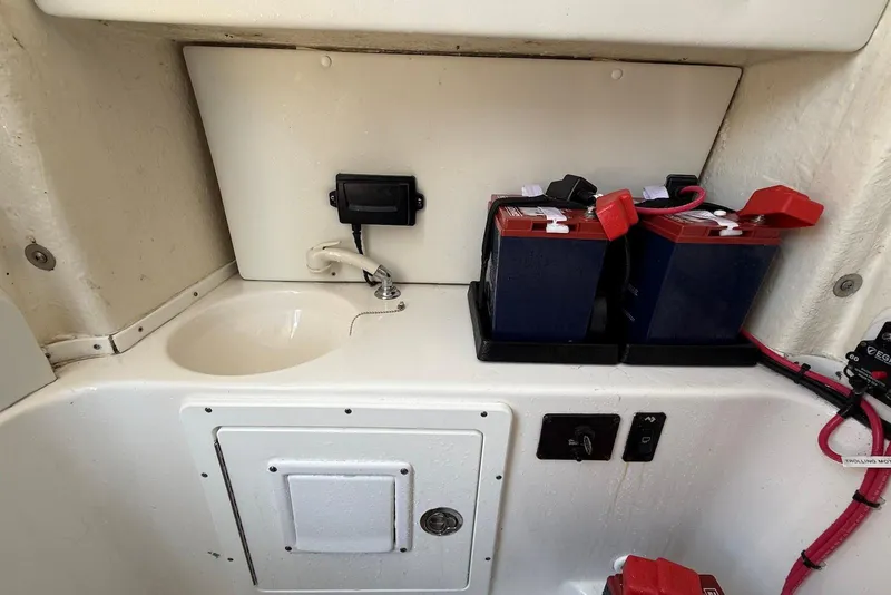 Slide: The Image of 2022 Tidewater 292 CC Adventure boat interior with batteries and sink. - 35