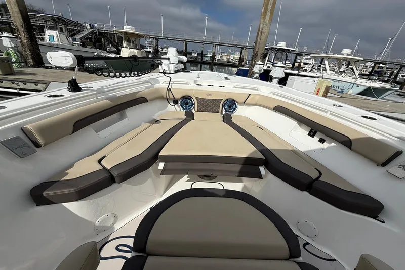 Slide: The Image of 2022 Tidewater 292 CC Adventure boat interior with cushioned seating at marina. - 6