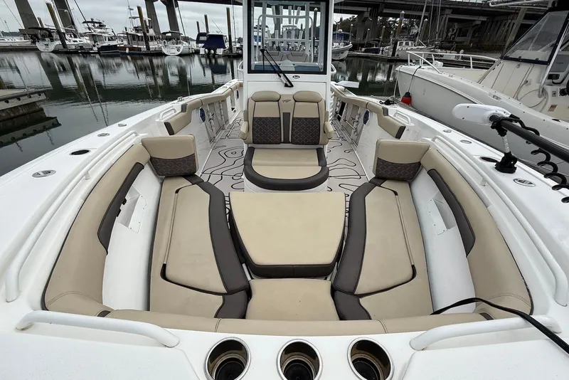 Slide: The Image of 2022 Tidewater 292 CC Adventure boat with spacious seating and modern design at a marina. - 8