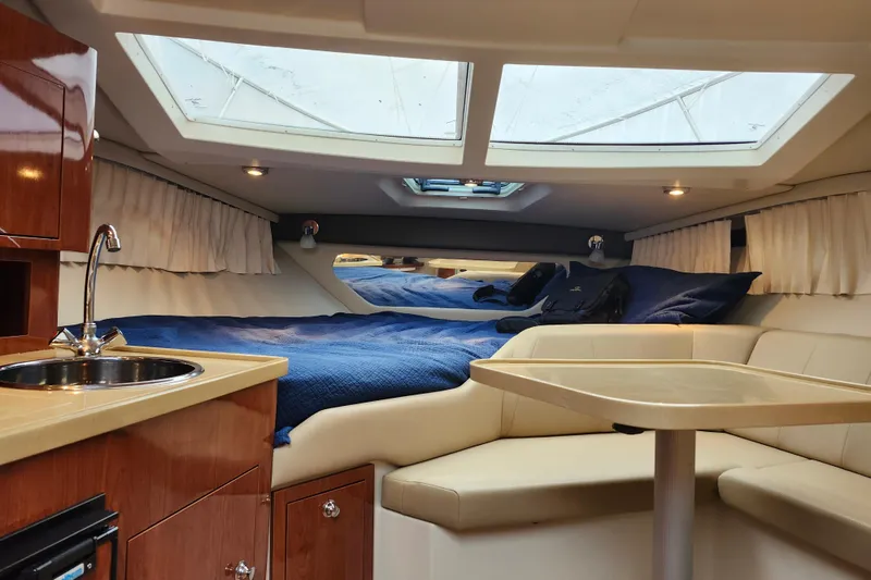 Slide: The Image of 2011 Regal 3060 Express Cruiser interior with kitchenette, seating, and bed. - 25
