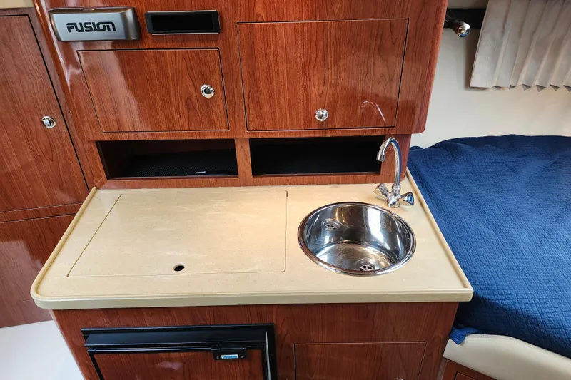 Slide: The Image of Interior of 2011 Regal 3060 Express Cruiser with beige seating and wall-mounted TV. - 29